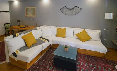 a living room with a white couch with yellow pillows at Little gem in the historical center of Athens in Athens