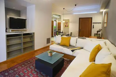 a living room with a white couch and a tv at Little gem in the historical center of Athens in Athens