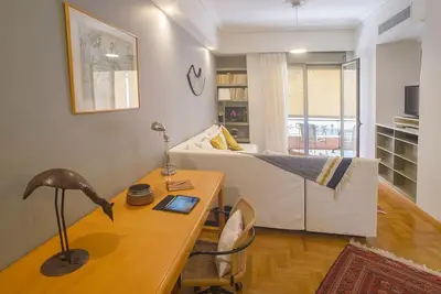a living room with a bed and a desk with a lamp at Little gem in the historical center of Athens in Athens
