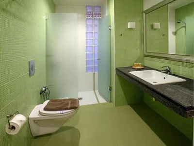 a green bathroom with a toilet and a sink at Little gem in the historical center of Athens in Athens