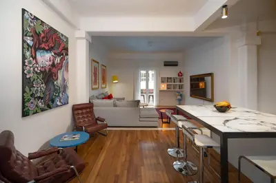 a living room with a large painting on the wall at Ebullience - Stylish & Chic Athens Apartment in Athens