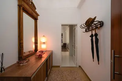a room with a mirror and a dresser with umbrellas at Ebullience - Stylish & Chic Athens Apartment in Athens