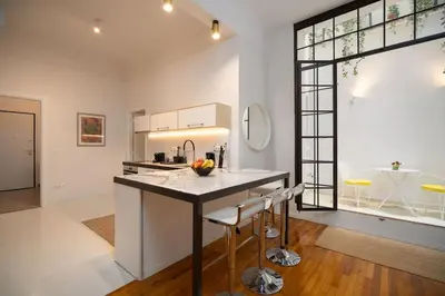 a kitchen with a island in the middle of a room at Ebullience - Stylish & Chic Athens Apartment in Athens