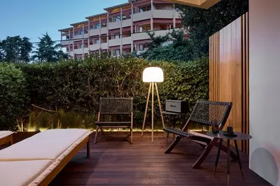 a patio with two chairs and a table and a lamp at Cama Luxury Suites Kavouri in Athens