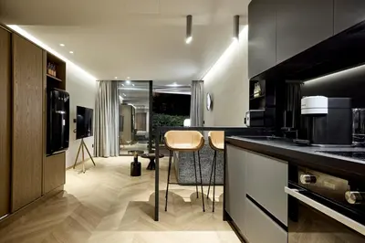 a kitchen with a counter and chairs in a room at Cama Luxury Suites Kavouri in Athens