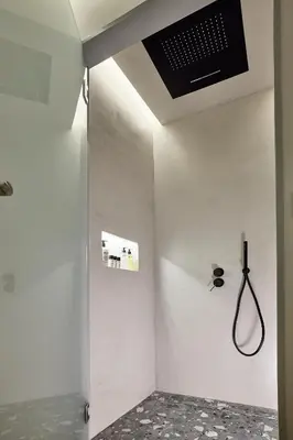 a bathroom with a shower with a ceiling fan at Cama Luxury Suites Kavouri in Athens