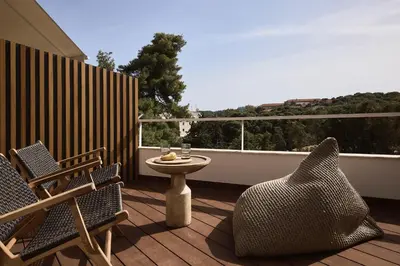 a patio with two chairs and a table on a balcony at Cama Luxury Suites Kavouri in Athens