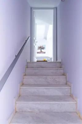 a staircase in a white house with a window at New Olivka House in Anavissos