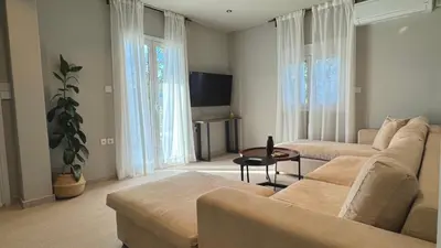 a living room with a couch and a table at Sand by Aestas Suites in Artemida