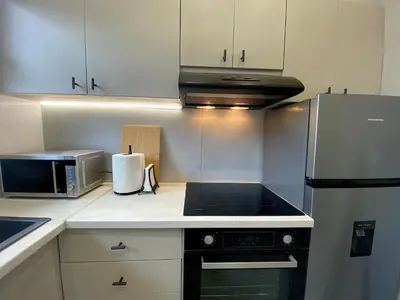 a kitchen with a stove top oven next to a microwave at Sand by Aestas Suites in Artemida