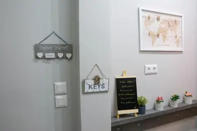 a shelf with a sign on a wall with plants at Melina’s Flat in Athens