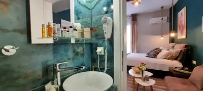 a bathroom with a sink and a room with a bed at Melina’s Flat in Athens