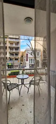 a patio with a table and chairs on a balcony at Melina’s Flat in Athens