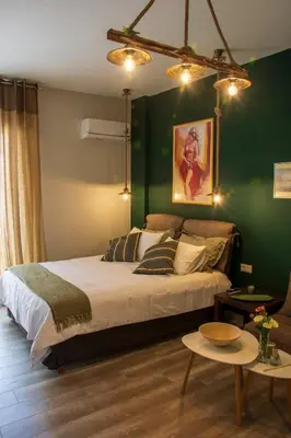 a bedroom with a bed and a green wall at Melina’s Flat in Athens